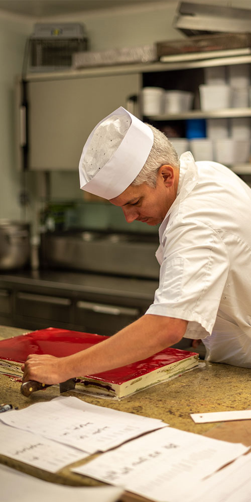Pâtissier qui découpe une pâtisserie